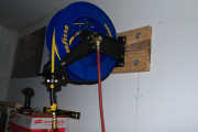 Air hose reel mounted to the mounting board with 3/8-inch by 1-1/2-inch stainless lag screws.